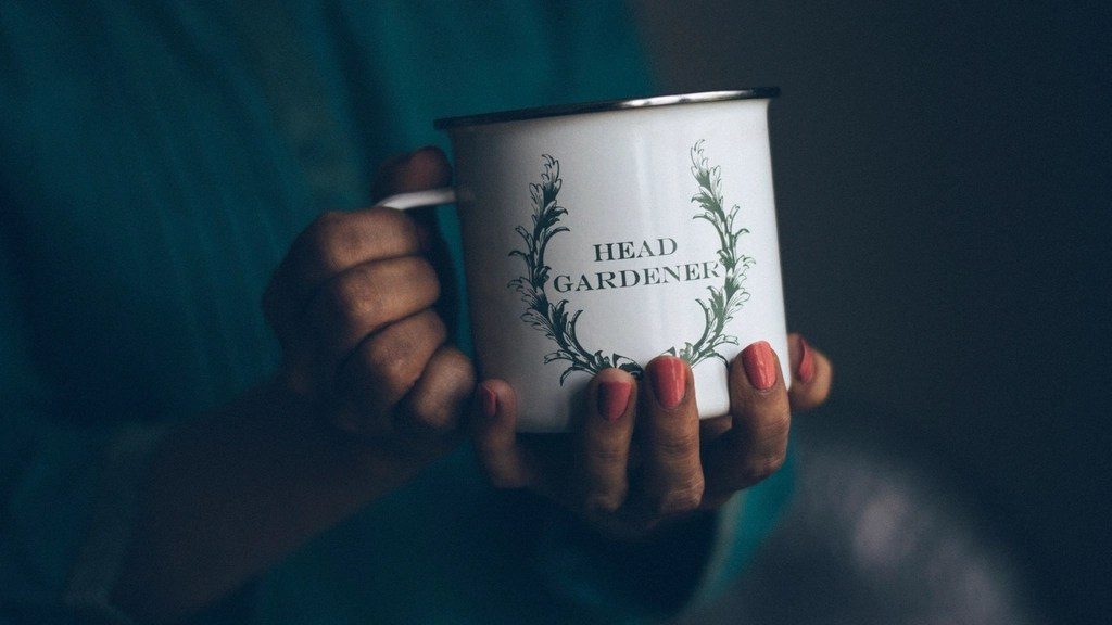 Hands holding an enamel mug close to the body