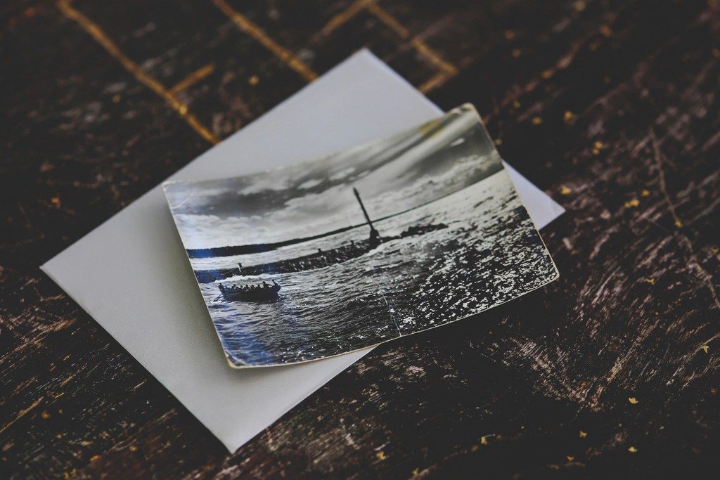 An old black and white photograph of a harbour lying on a wooden table