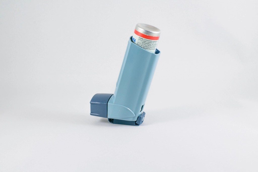 A blue inhaler standing on a plain background