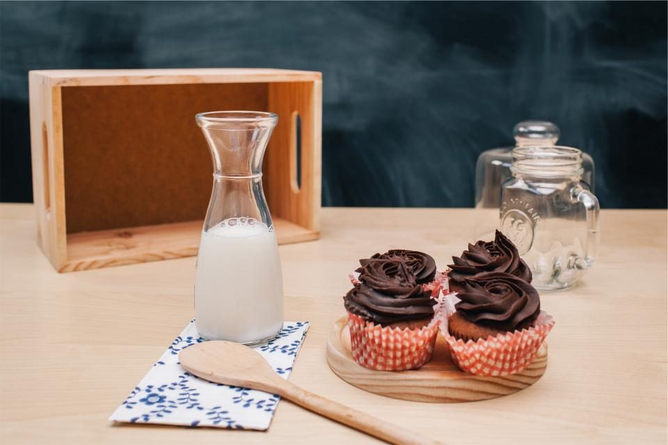 A glass jug of milk on a wooden table